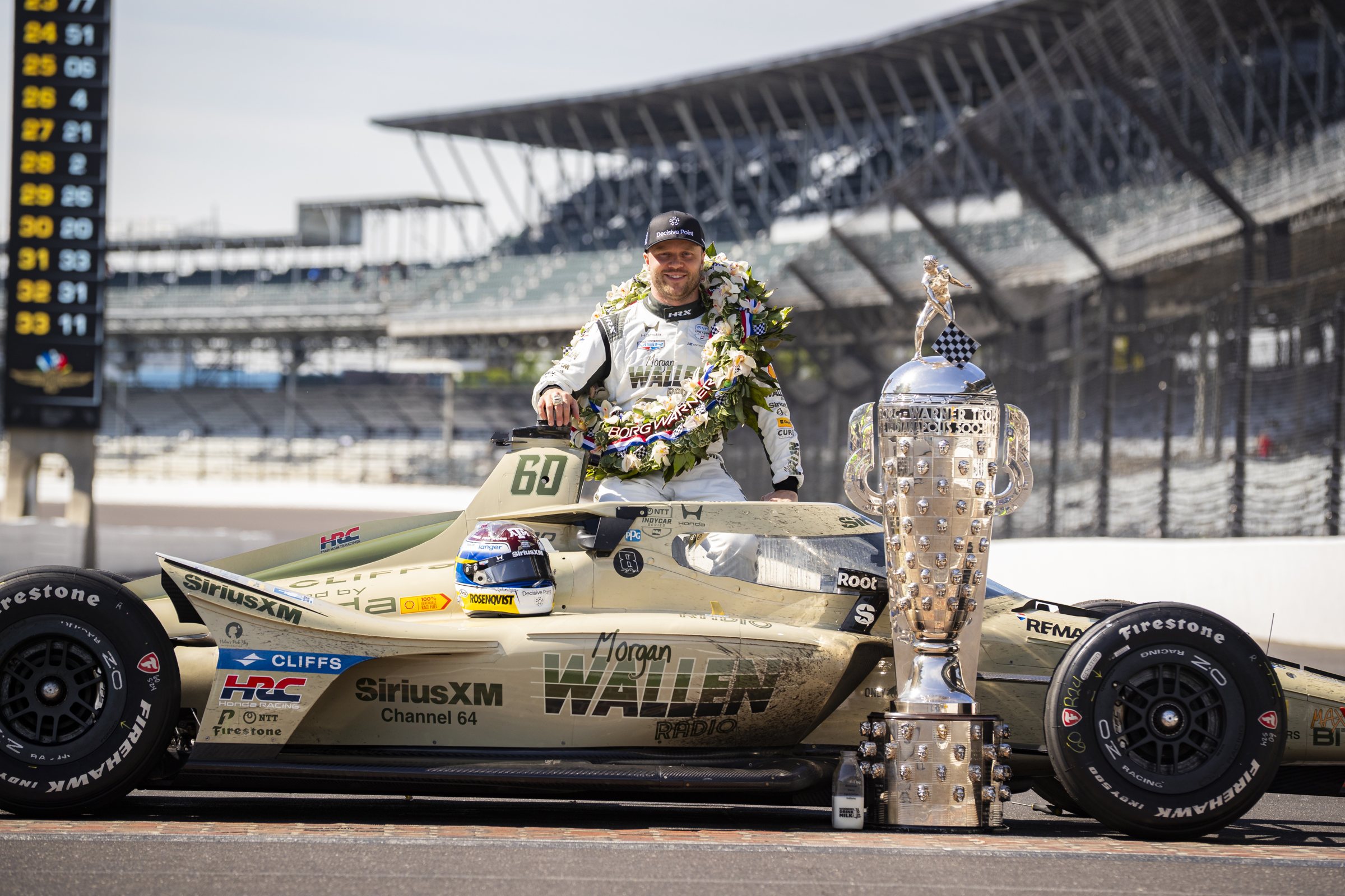 Felix Rosenqvist with the Borg-Warner Trophy and his car on the yard of bricks after winning the 2026 Indianapolis 500